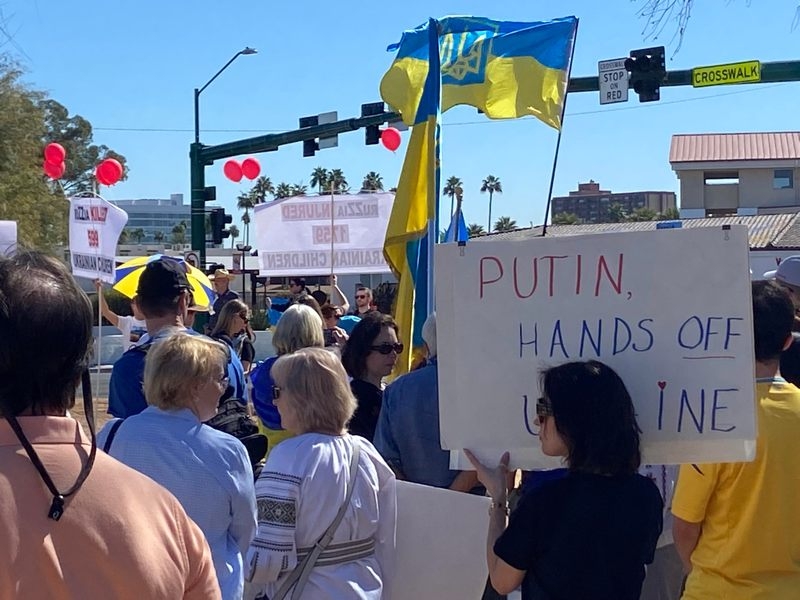 A group of people in Phoenix Arizona hold up flags and signs to show their solidarity with Ukraine on the 3-year anniversary of Russia's invasion. Photo by Keith Brown