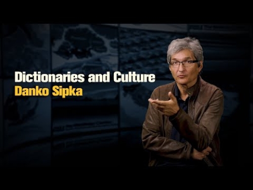 A person in a brown jacket speaks, with "Dictionaries and Culture Danko Sipka" text beside them on a dark background.